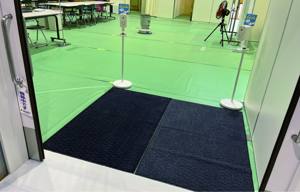 避難所入口に設置された衛生マットと衛生設備